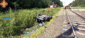 Po zderzeniu z pociągiem pasażerskim samochód osobowy spadł z nasypu kolejowego (fot. OSP Kórnik)