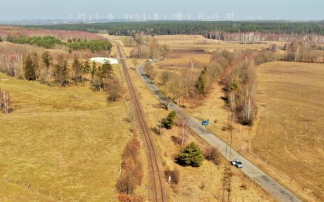 Tory na linii Lębork - Łeba, w tle elektrownia wiatrowa (fot. Szymon Danielek / PKP PLK)