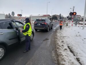 Przedstawiciele PLK i SOK wręczają ulotki kierowcom przed przejazdem kolejowo-drogowym w Tucholi (fot. Przemysław Zieliński / PKP PLK)