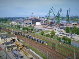 Pociąg SKM Trójmiasto na tle stoczni (fot. SKM Trójmiasto / archiwum)