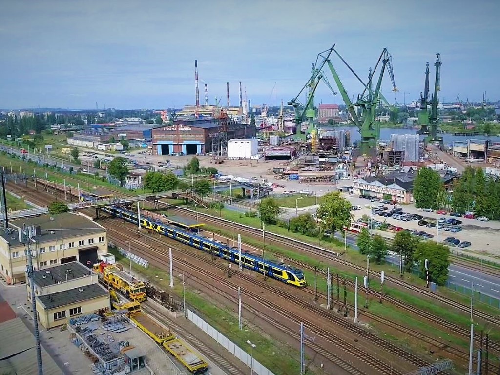 Pociąg SKM Trójmiasto na tle stoczni (fot. SKM Trójmiasto / archiwum)